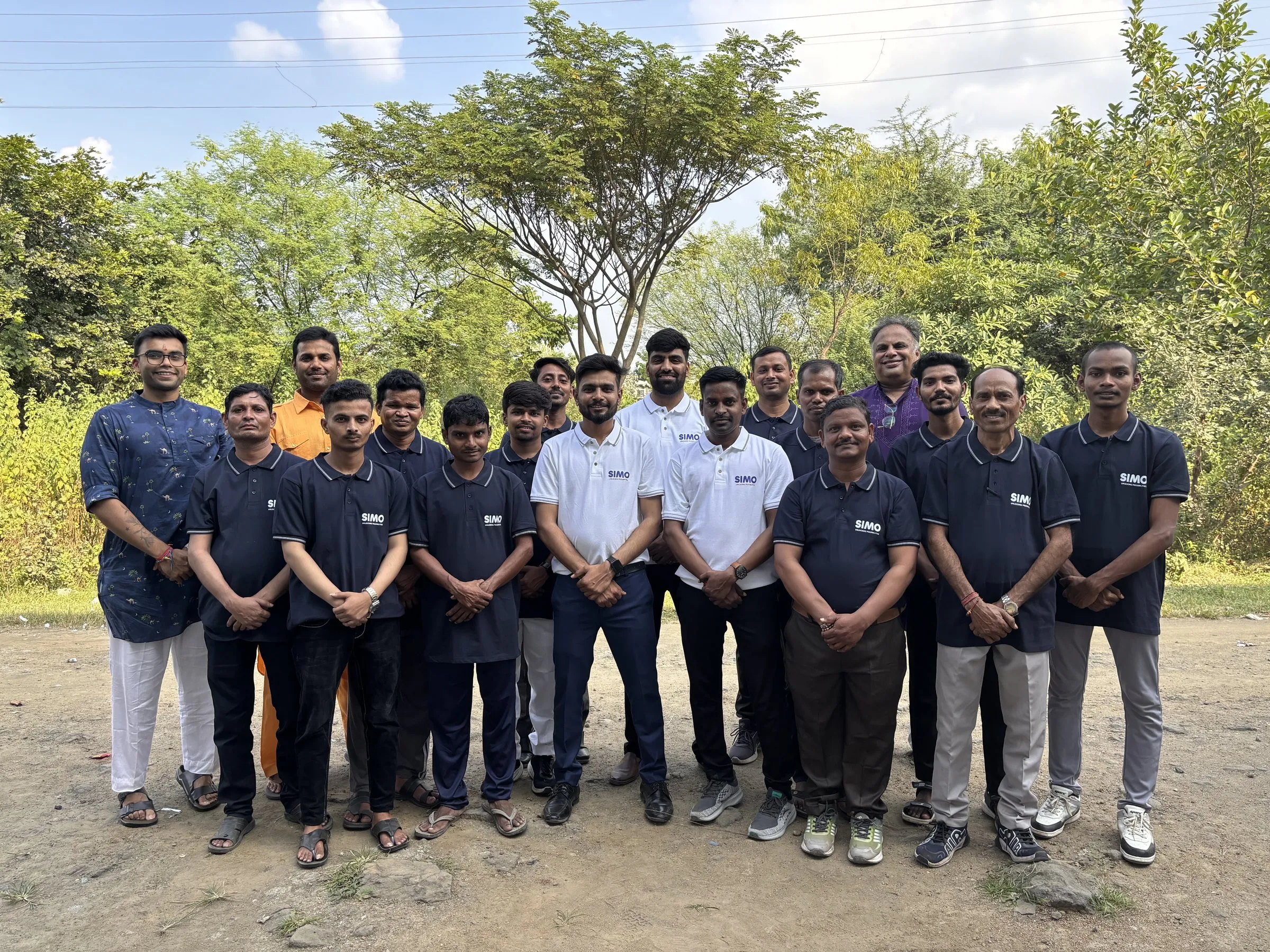 The SIMO team, in navy and white SIMO polos, standing outdoors