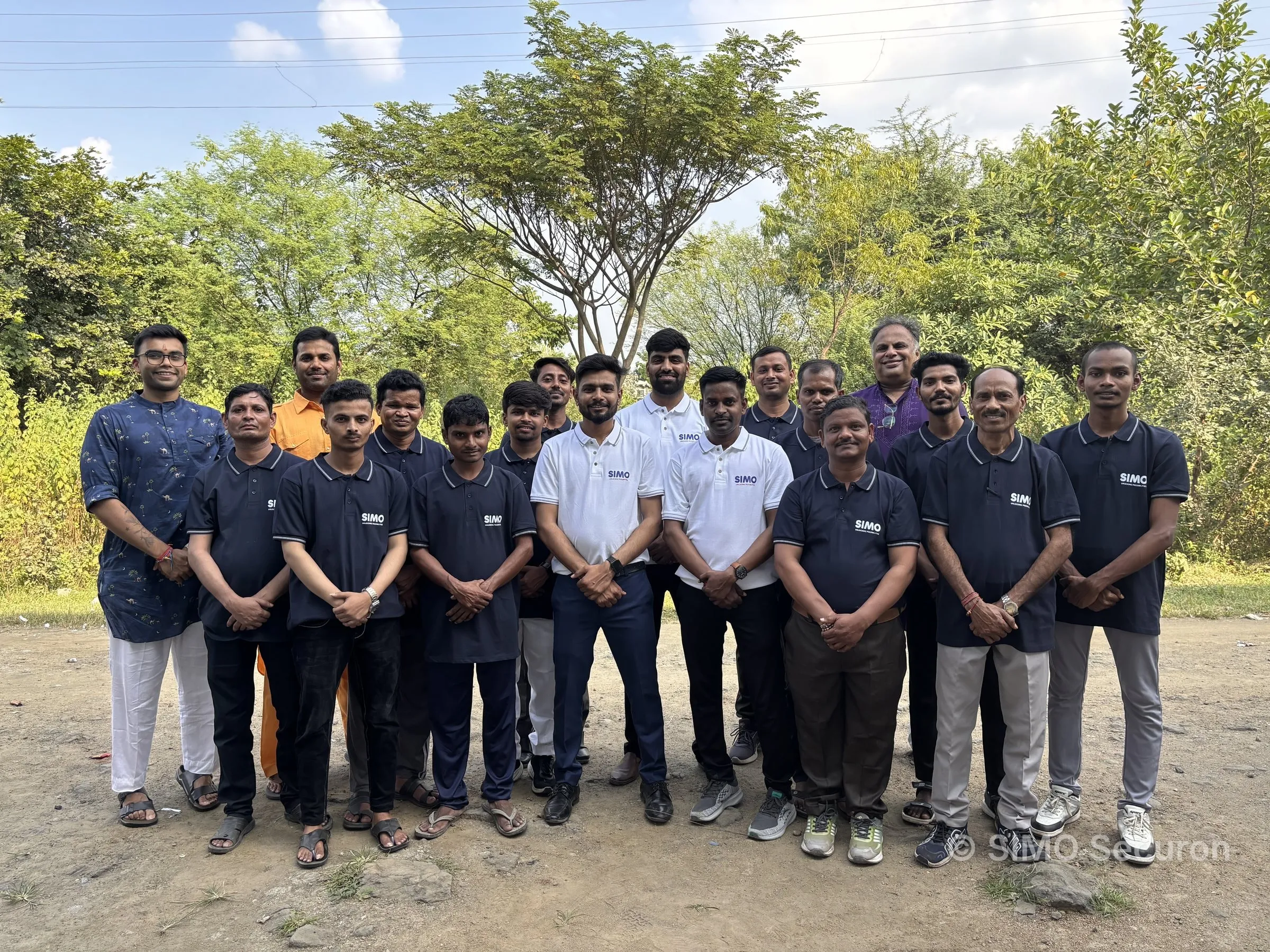 The SIMO Securon team in navy and white SIMO polos, standing outdoors