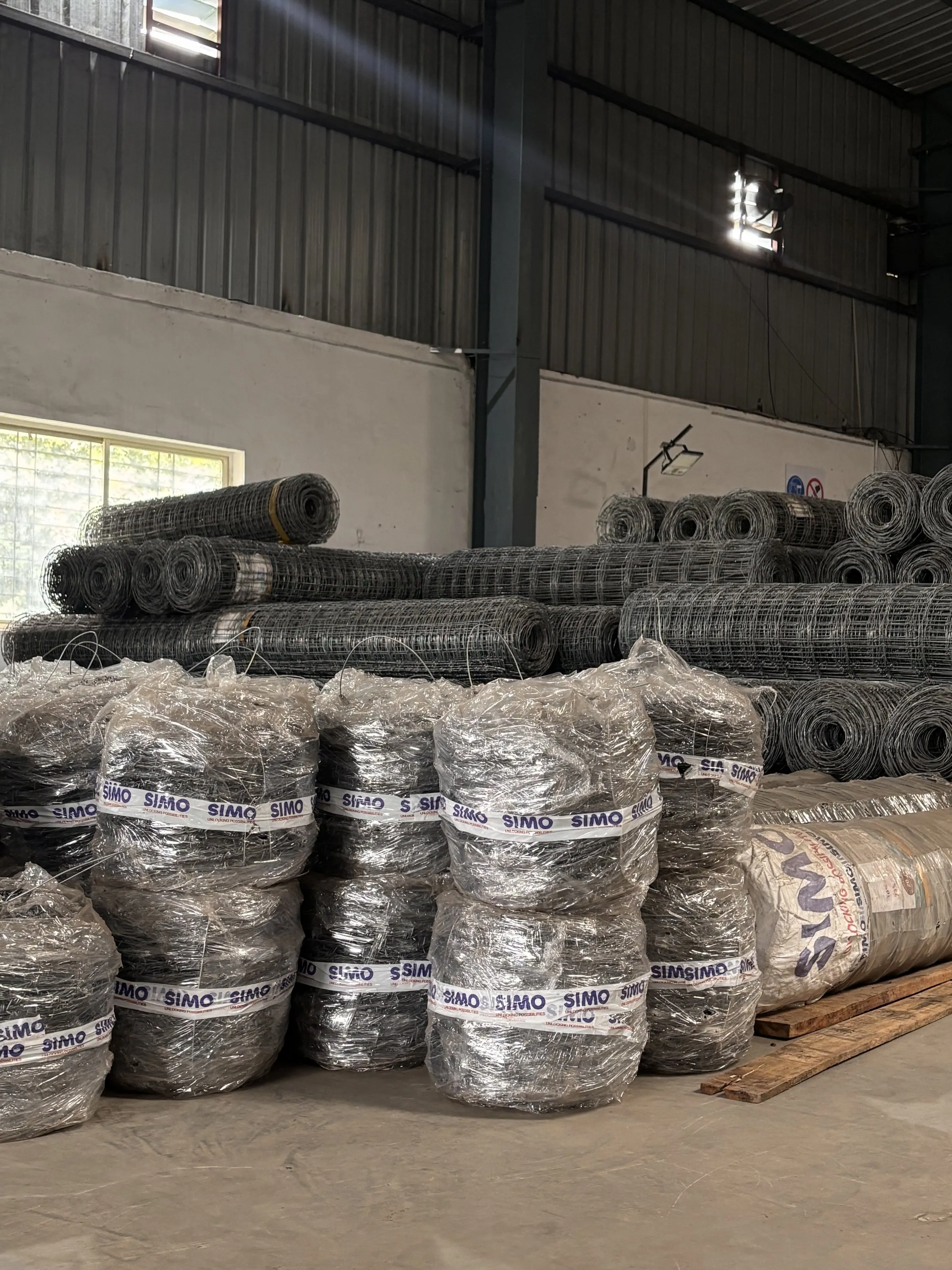 RTHT barbed wire coils and knotted fence rolls stacked in the SIMO warehouse